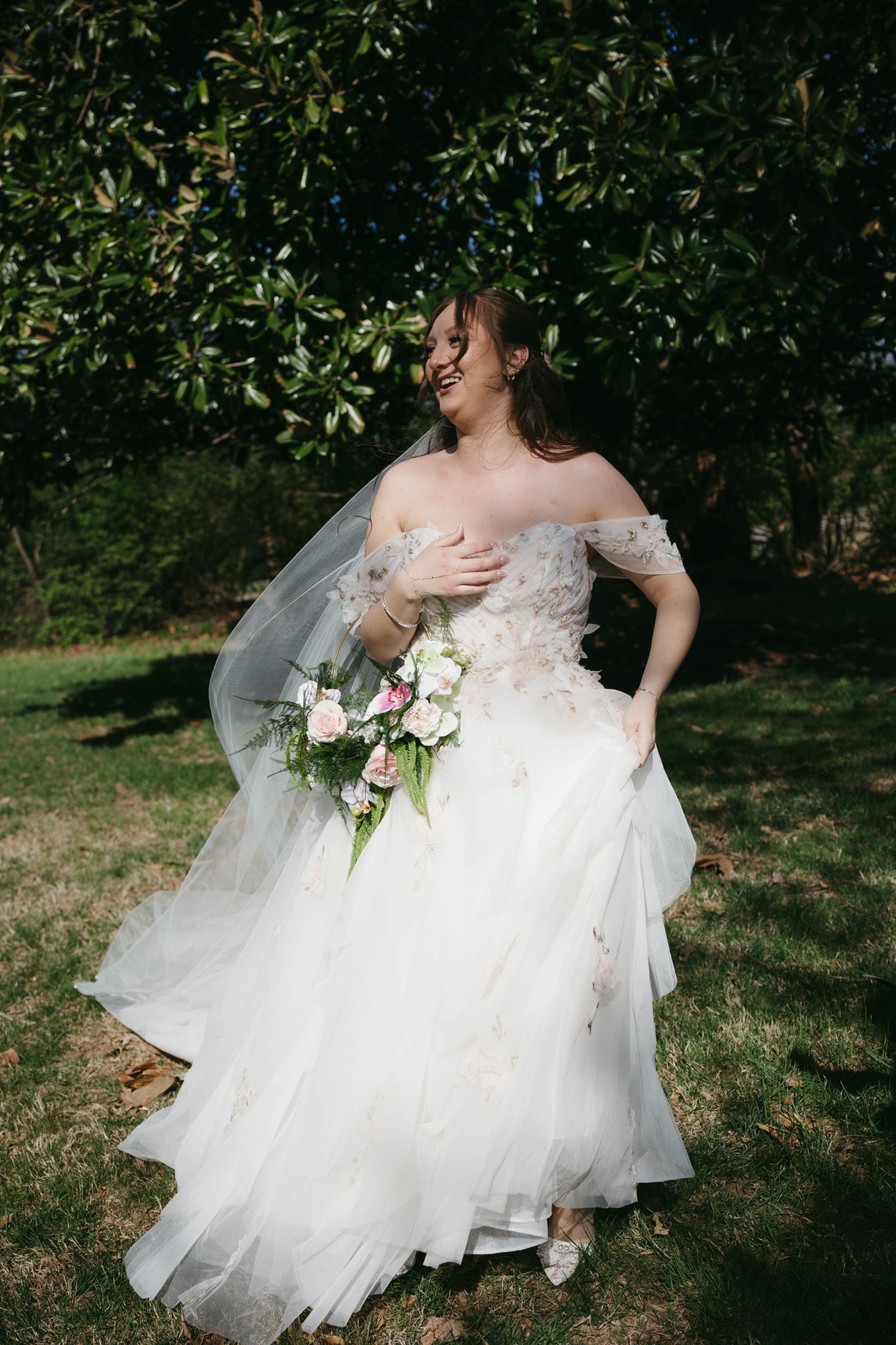 Bride in a floral gown laughing outdoors