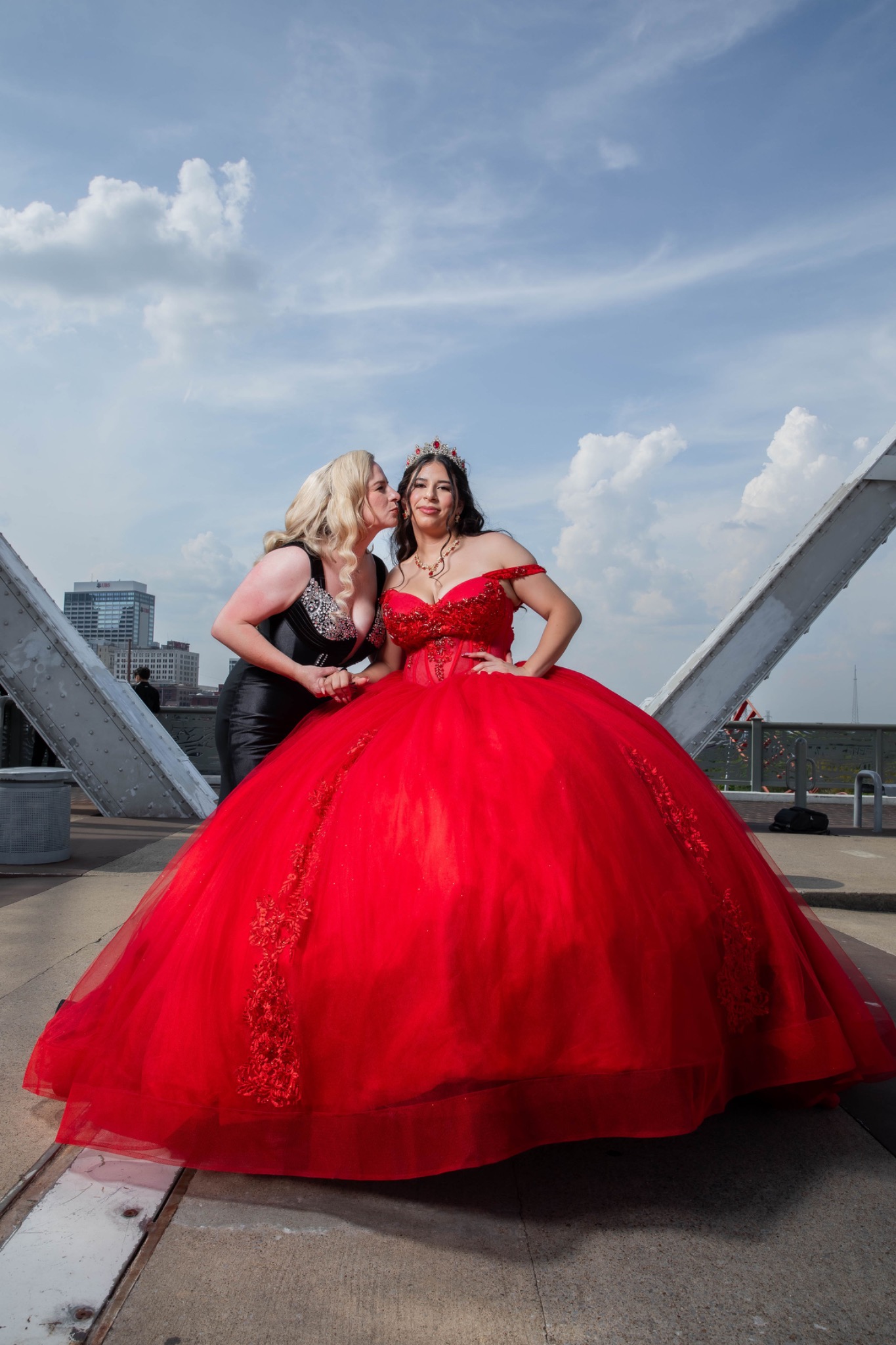Quinceañera in a red gown sharing a moment with her mother